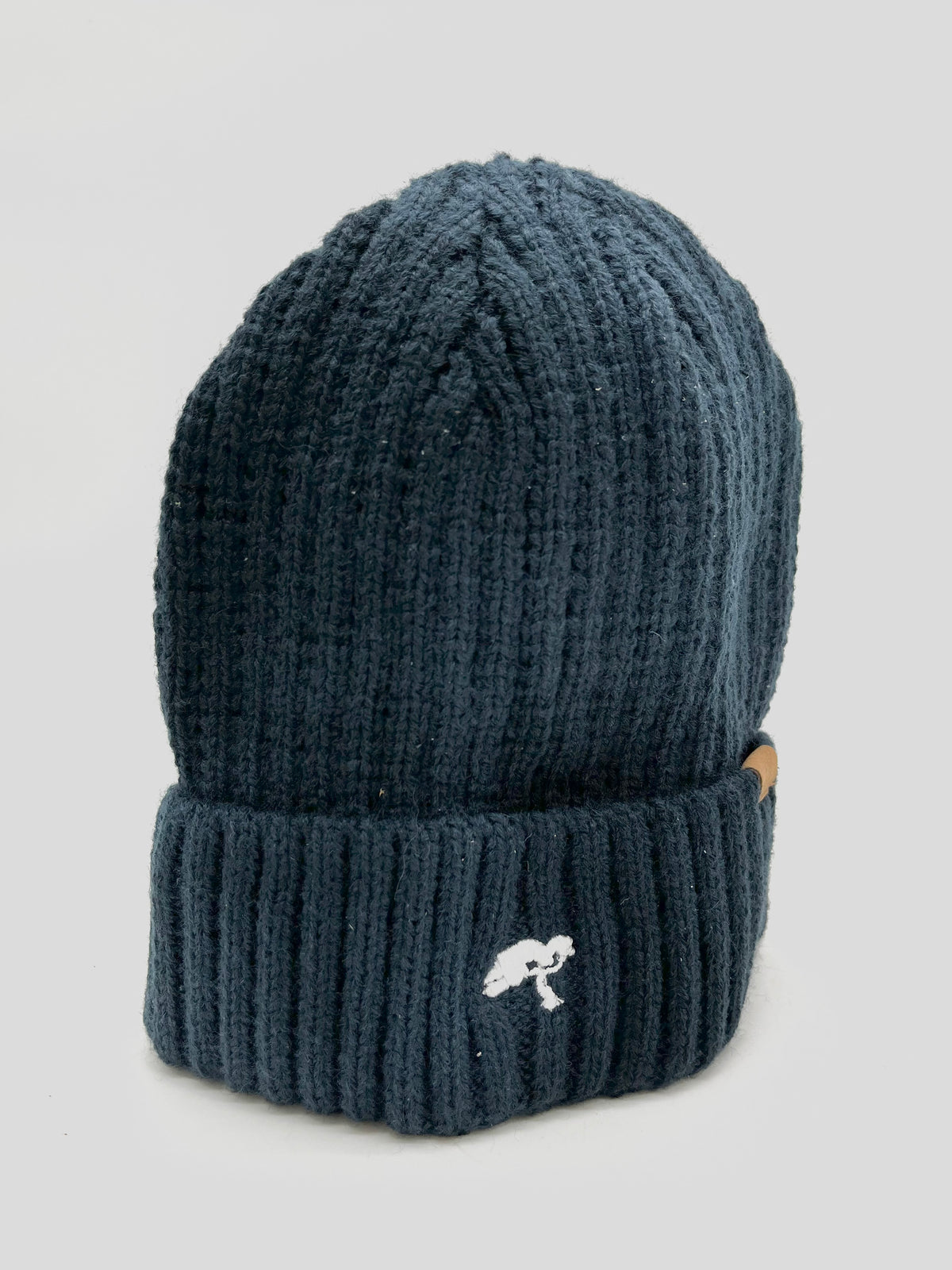 A dark blue cotton beanie with a visible brand tag on it.