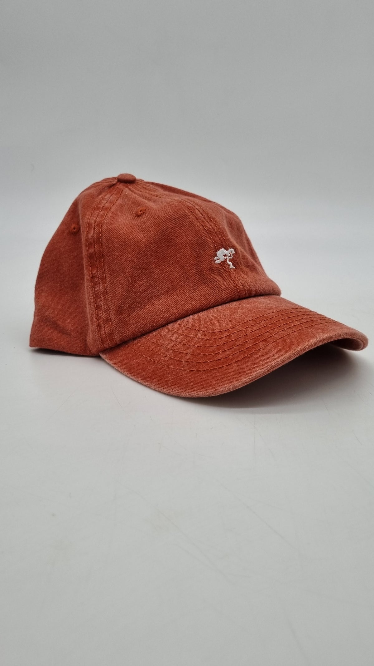A red colored cap with a logo on the front.