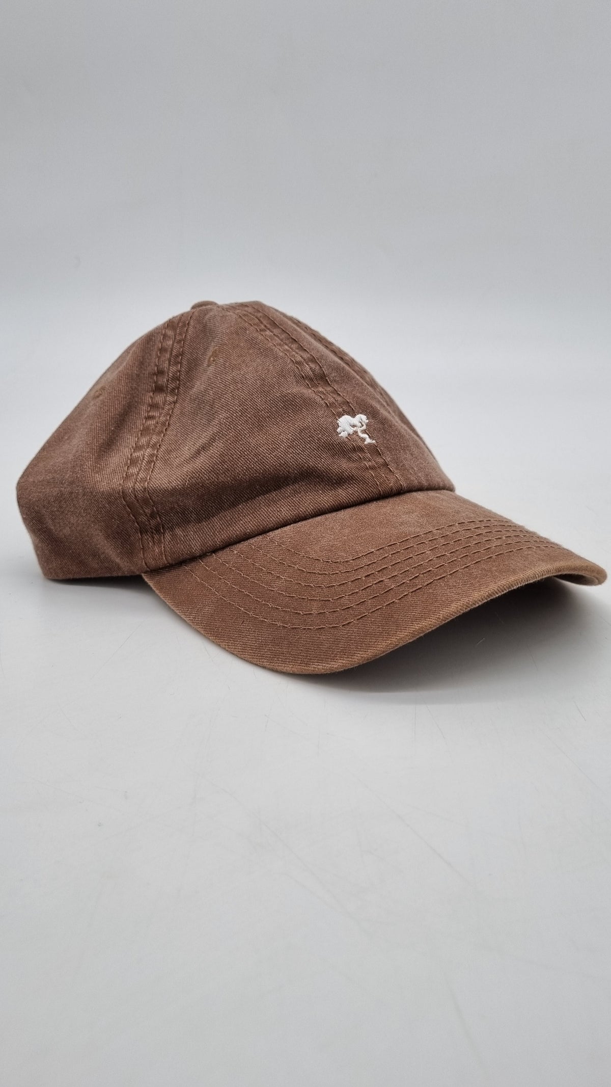 A brown colored cap with a logo on the front.