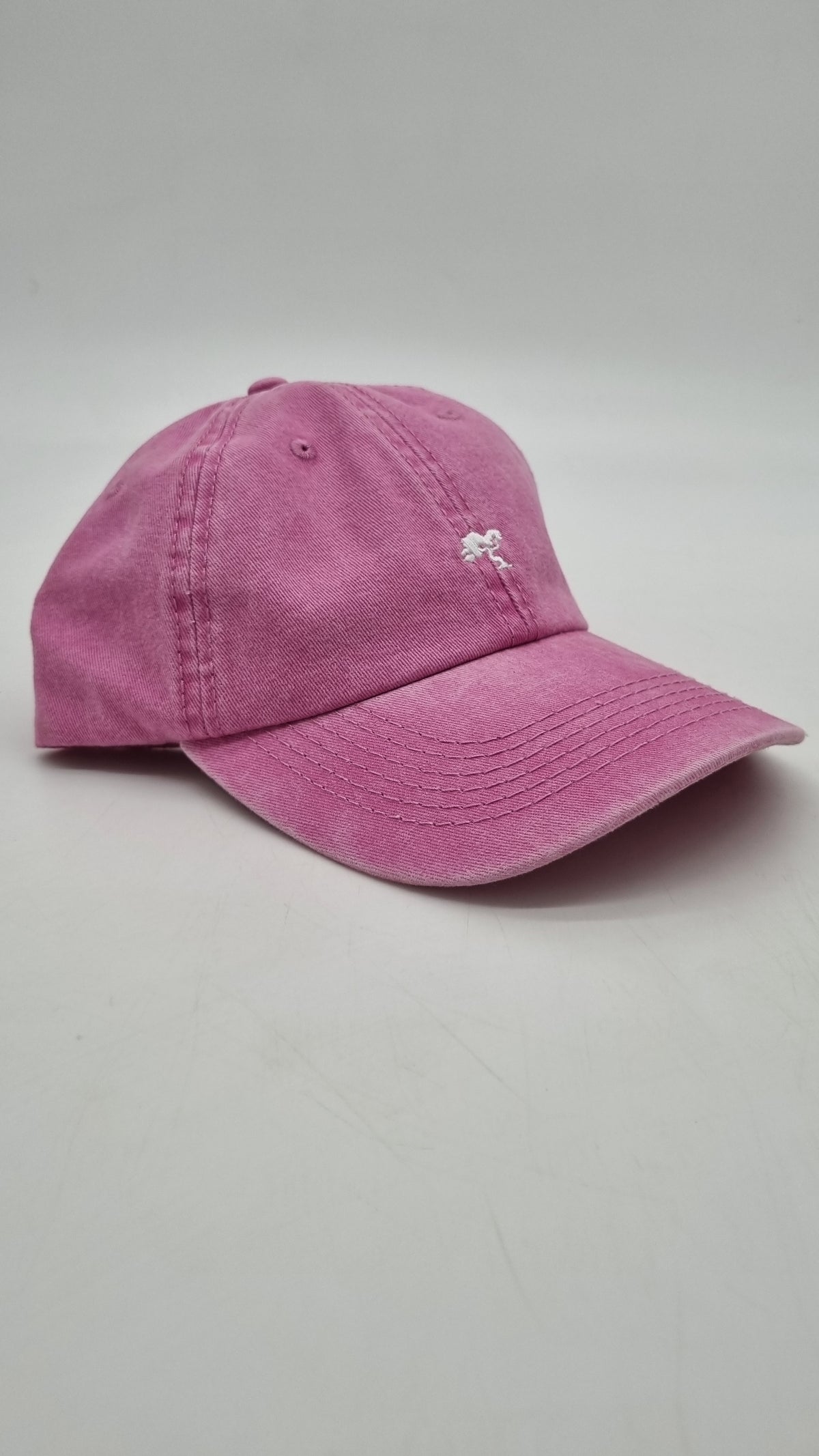 A pink colored cap with a logo on the front.