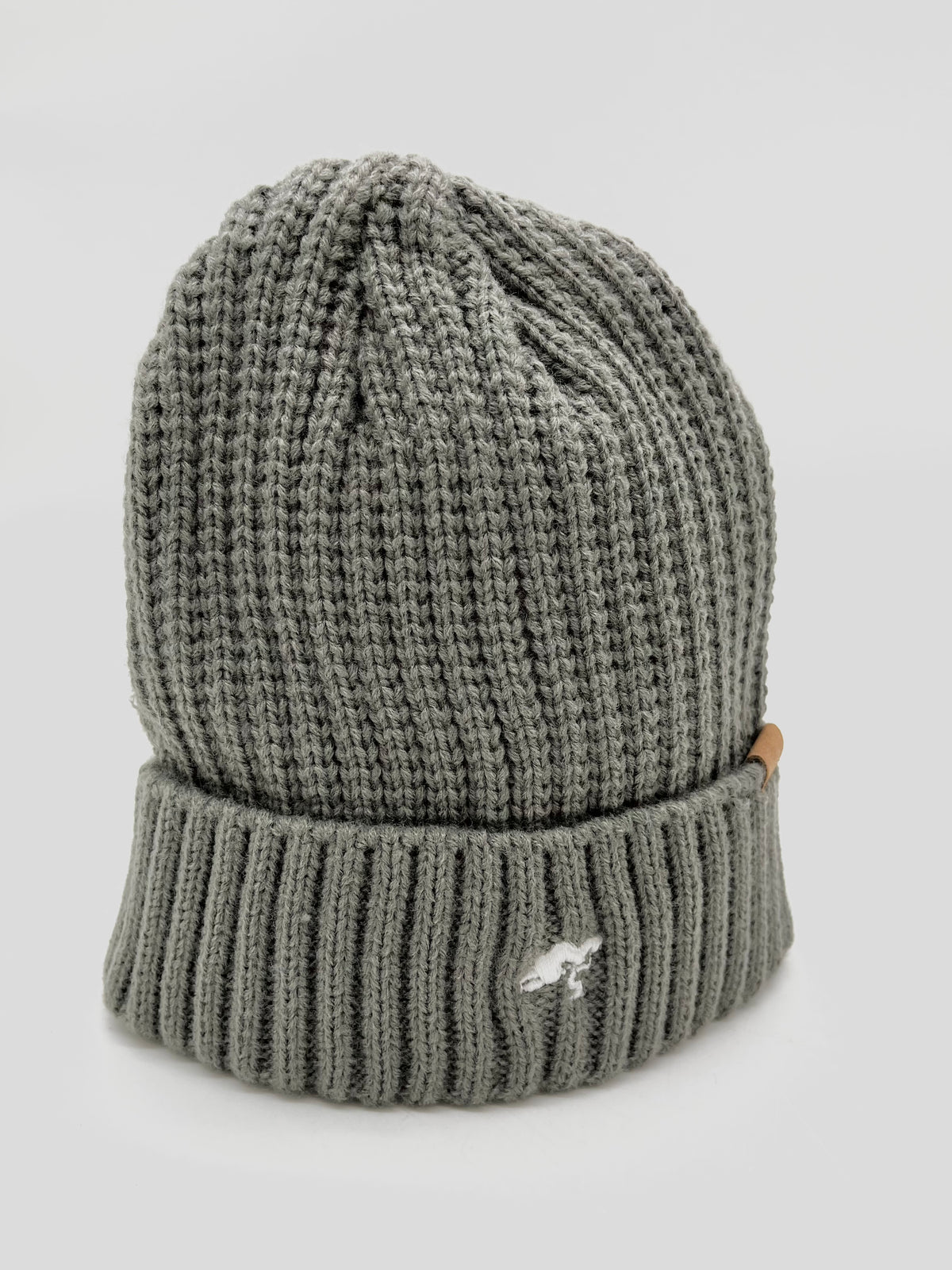 A black cotton beanie with a visible brand tag on it.