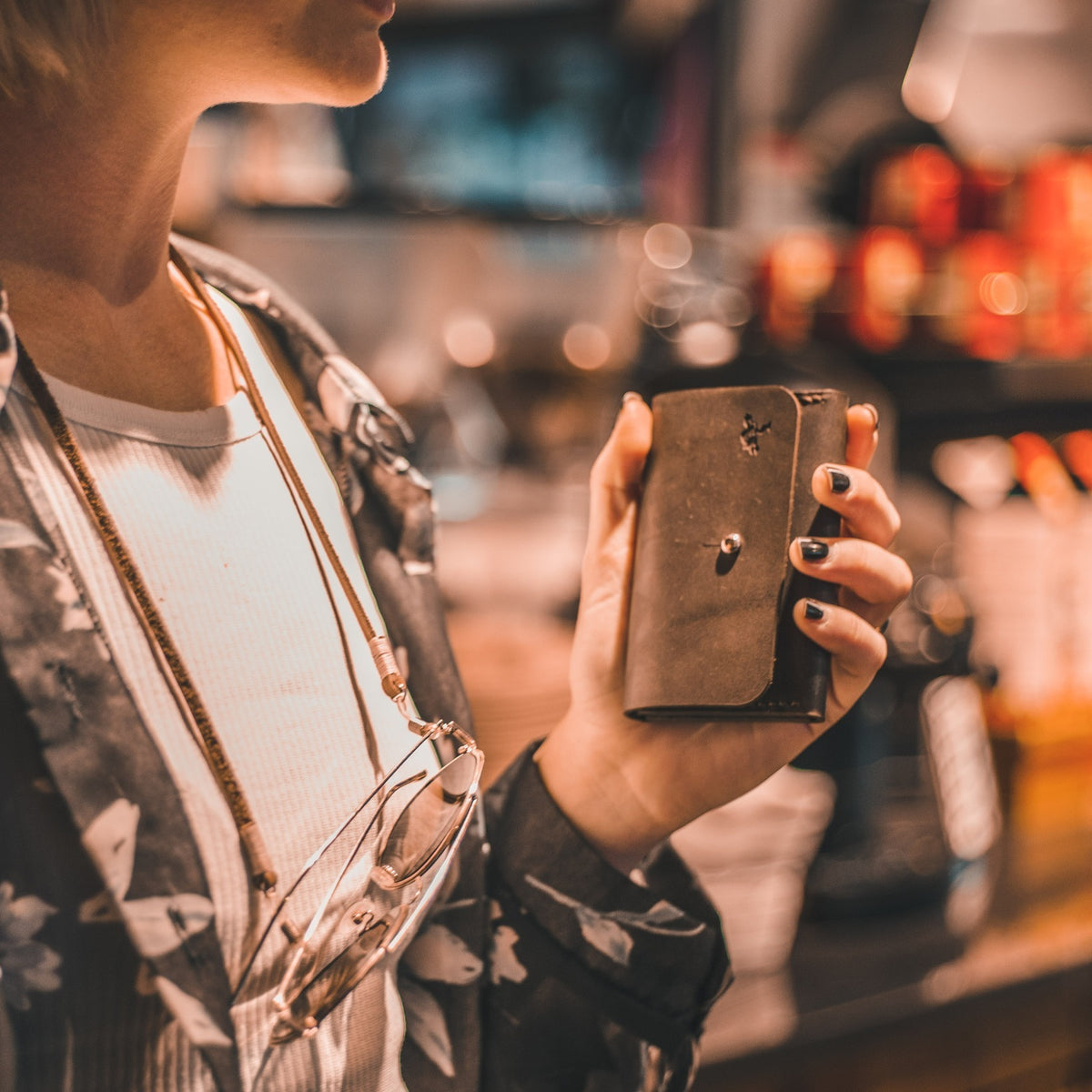 Person holding a brown leather wallet with a blurred background