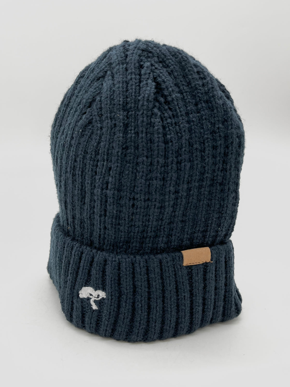 A black cotton beanie with a visible brand tag on it.