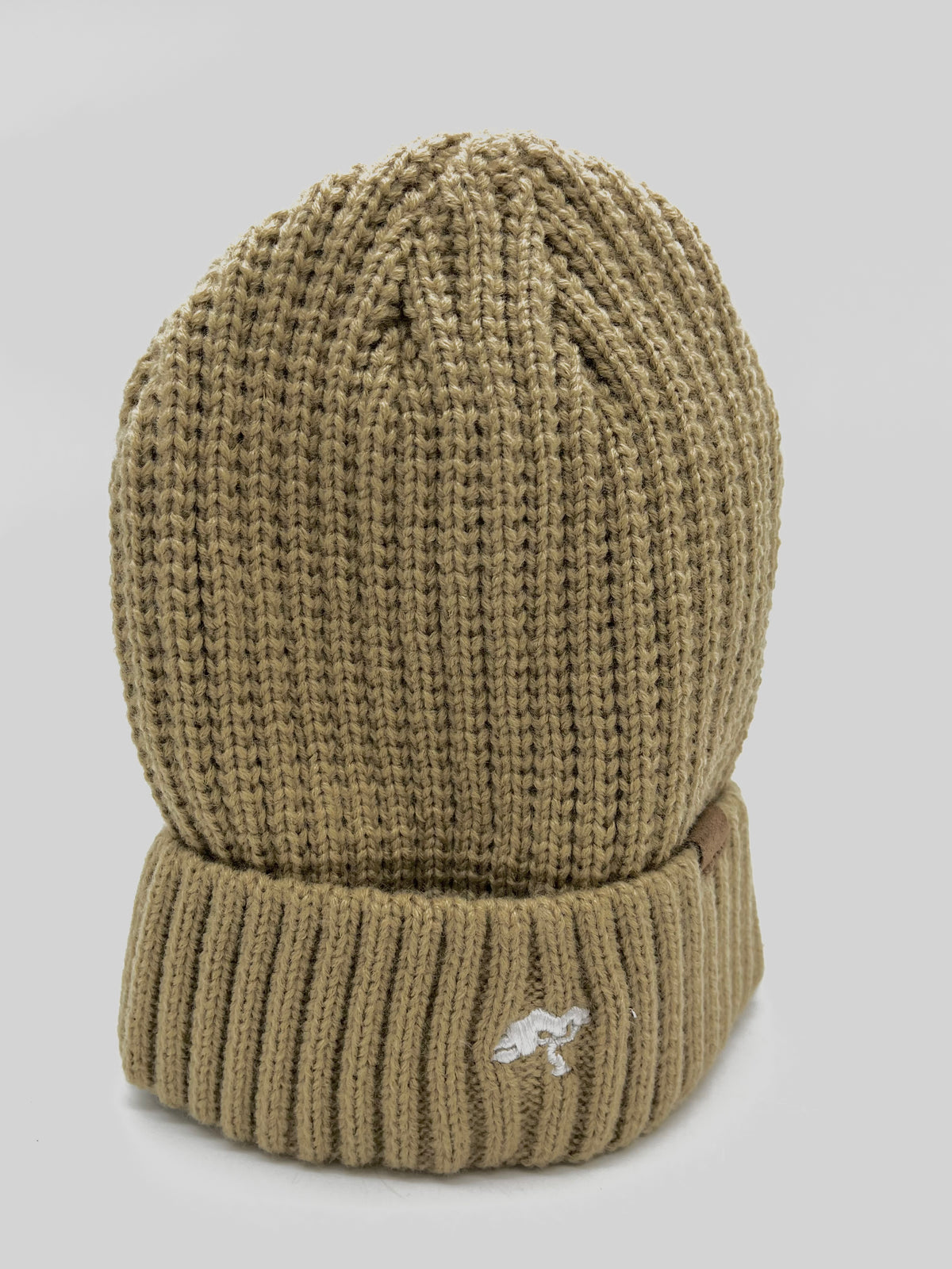 A beige cotton beanie with a visible brand tag on it.