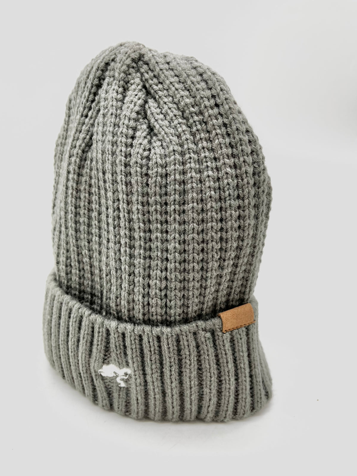 A grey cotton beanie with a visible brand tag on it.
