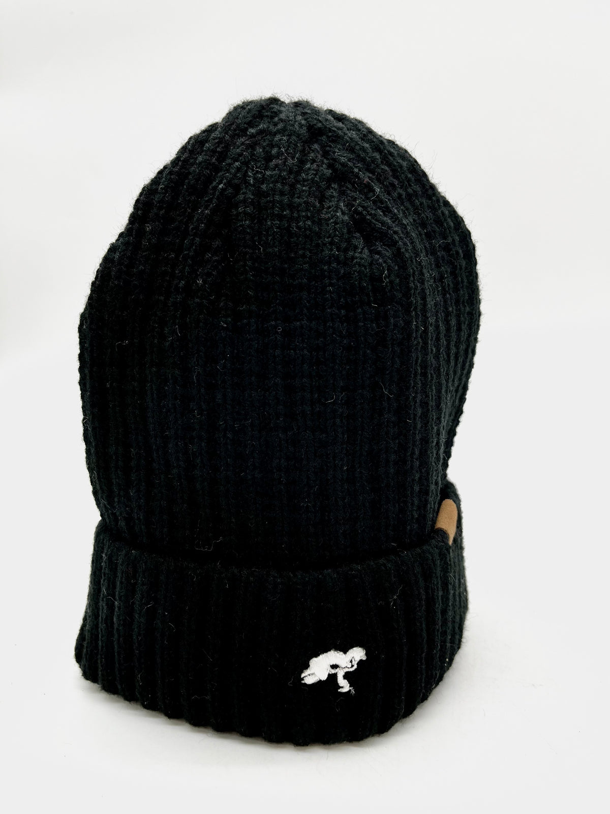 A black cotton beanie with a visible brand tag on it.