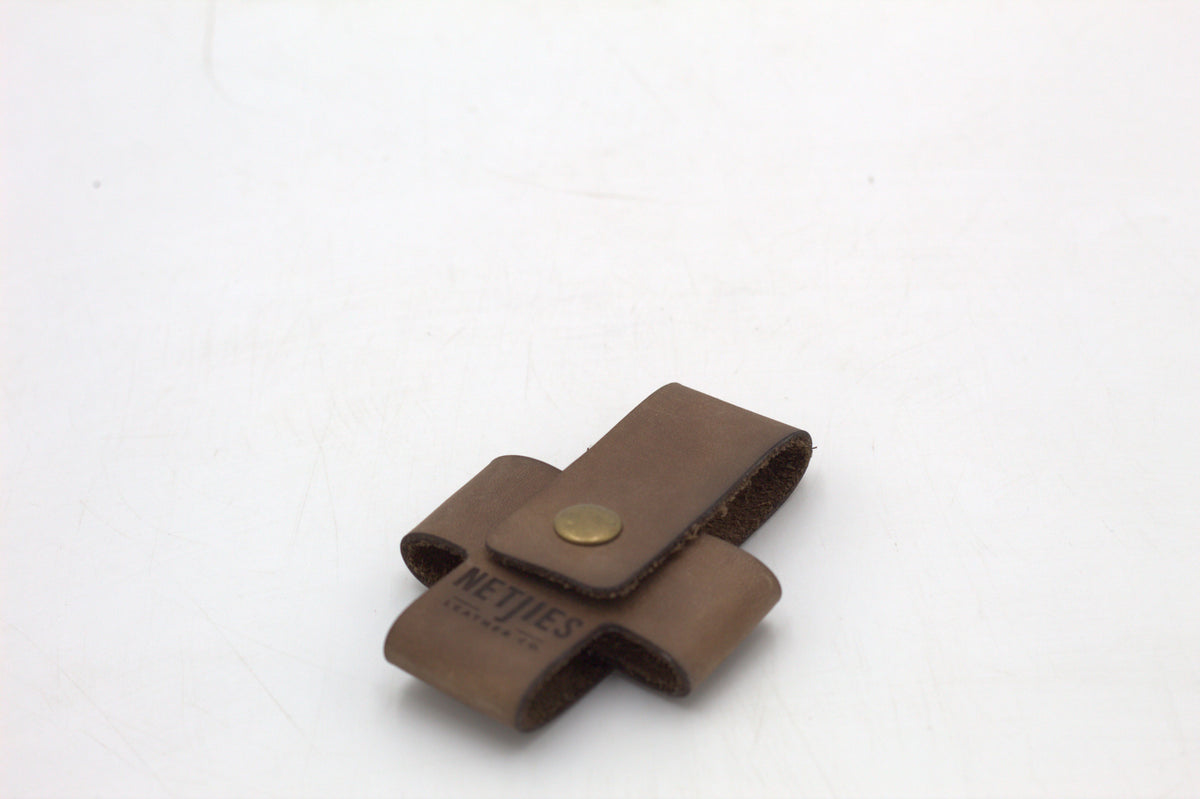 A brown leather cross wallet with a buckle closure.