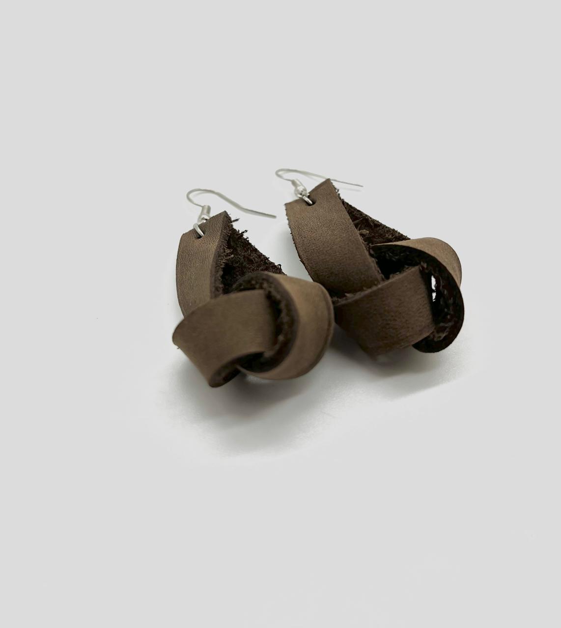 A pair of brown leather earrings with a simple loop design, suspended from silver hooks.