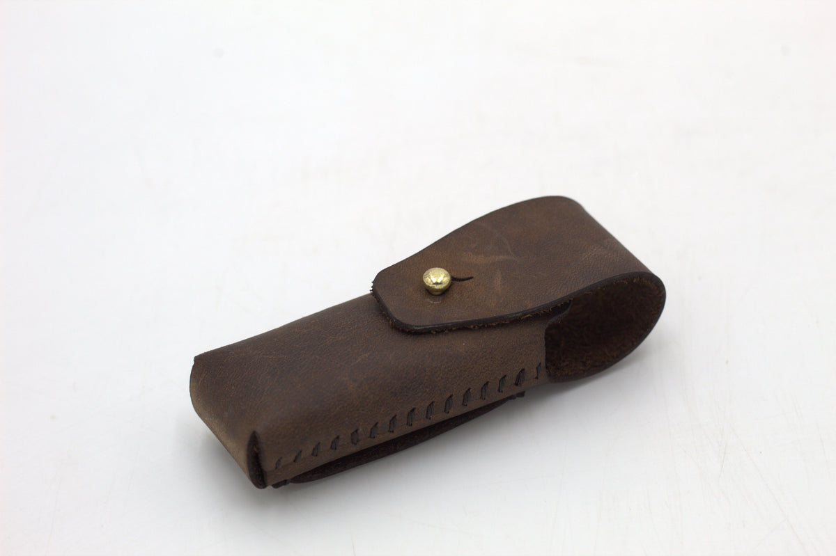 A black leather multitool pouch against a white background