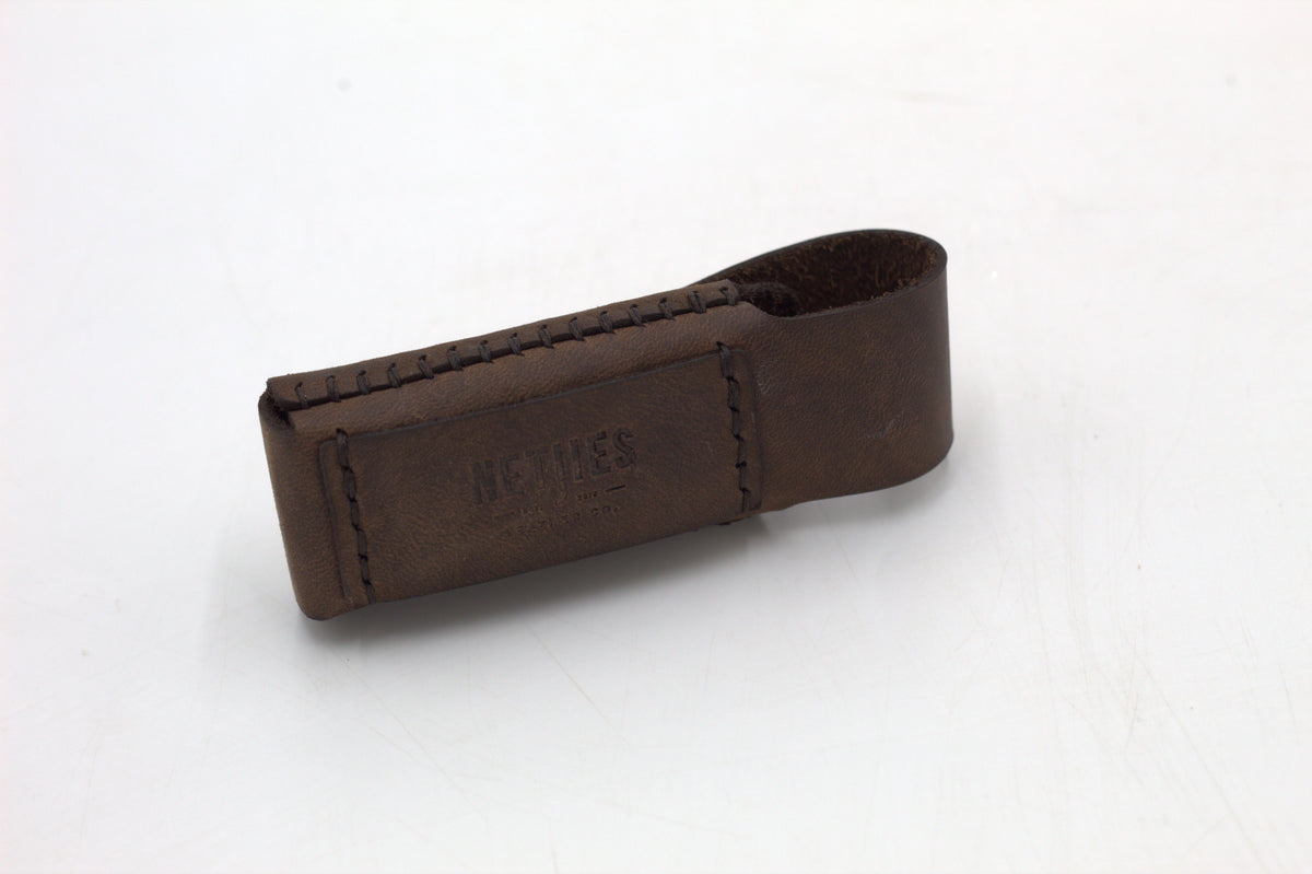 A black leather multitool pouch against a white background