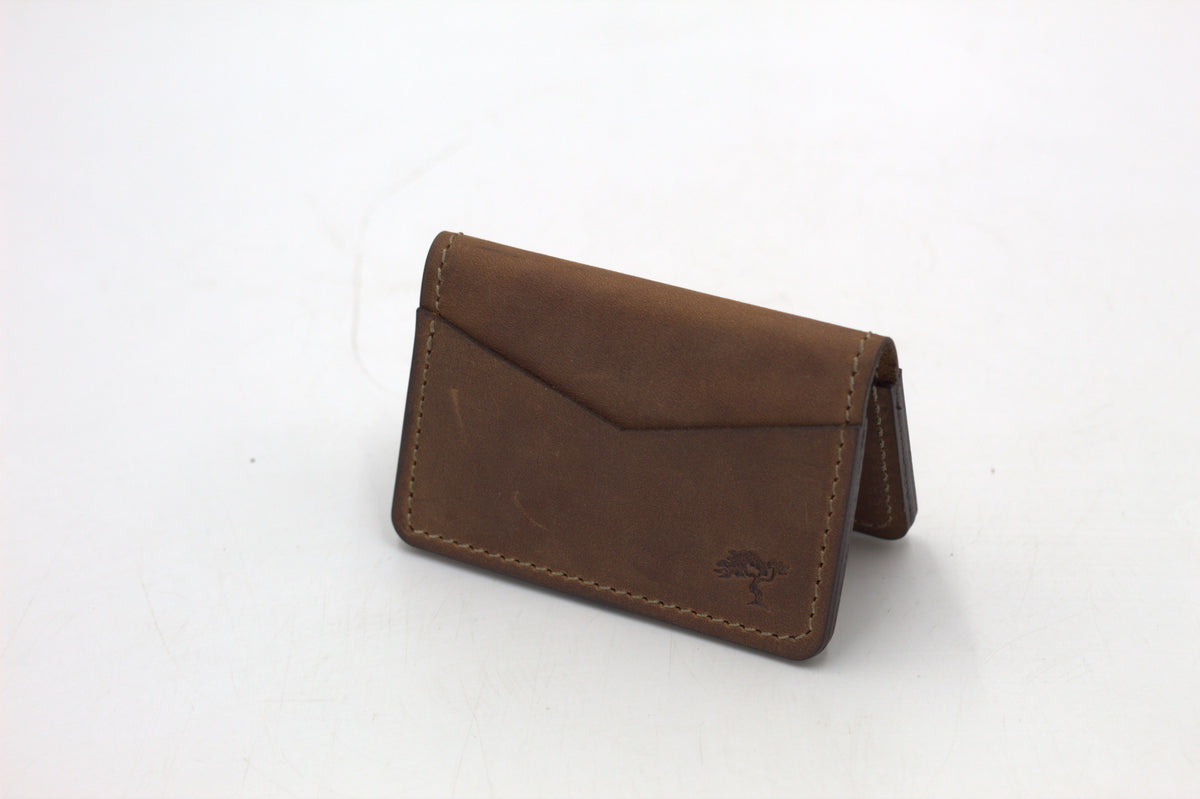 A black leather wallet with a front flap and metal accents, isolated on a white background.