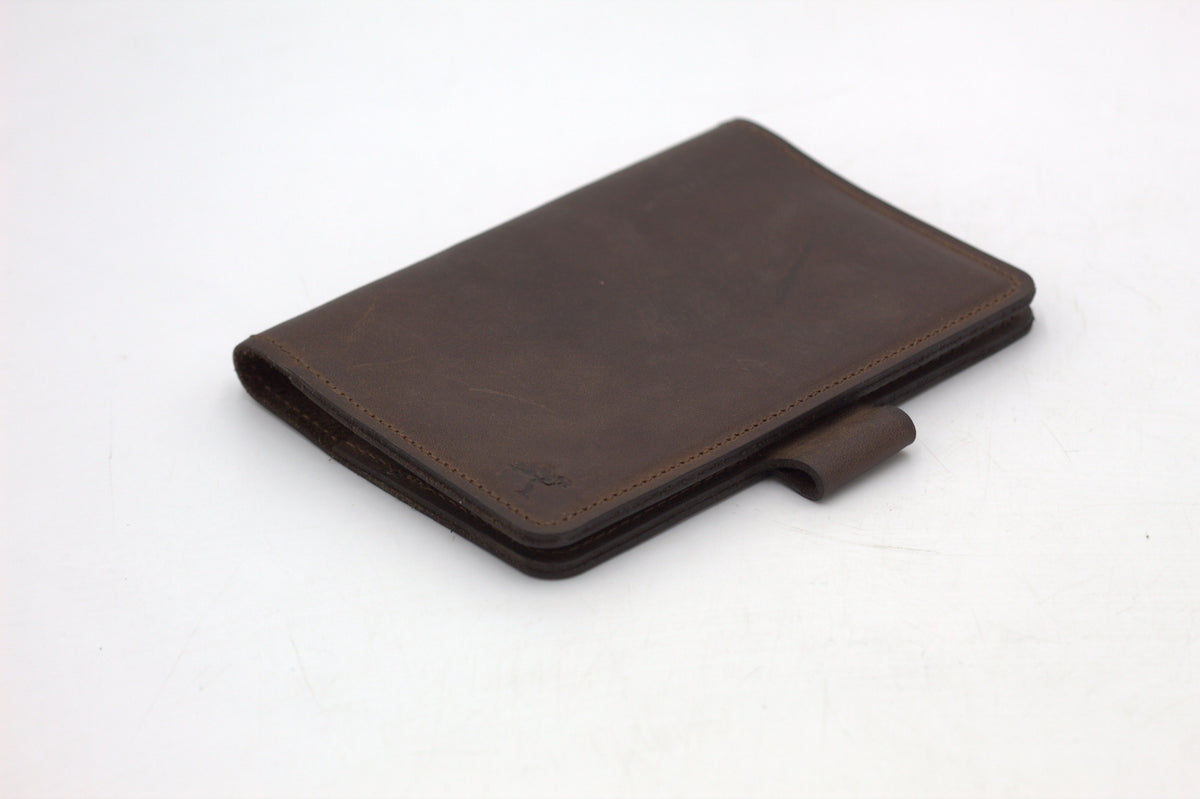 A black travel-wallet with a snap closure, displayed on a white background.