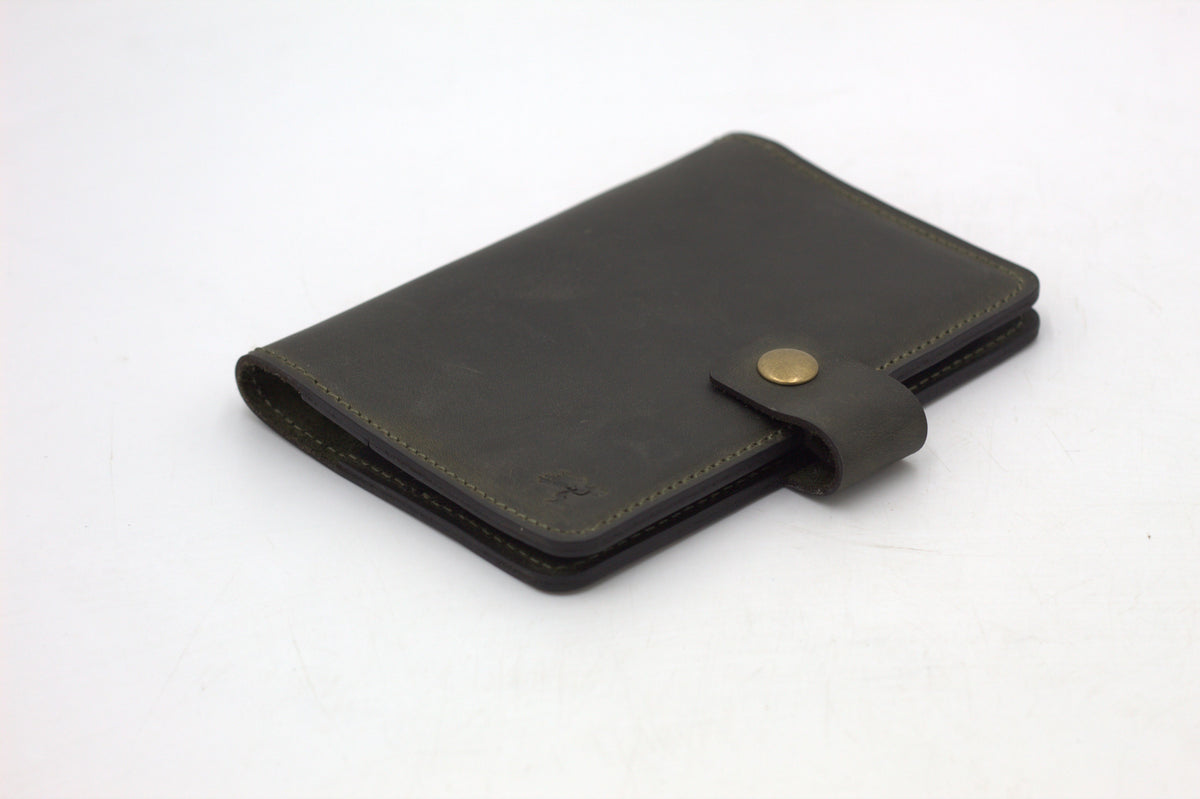 A black travel-wallet with a snap closure, displayed on a white background.