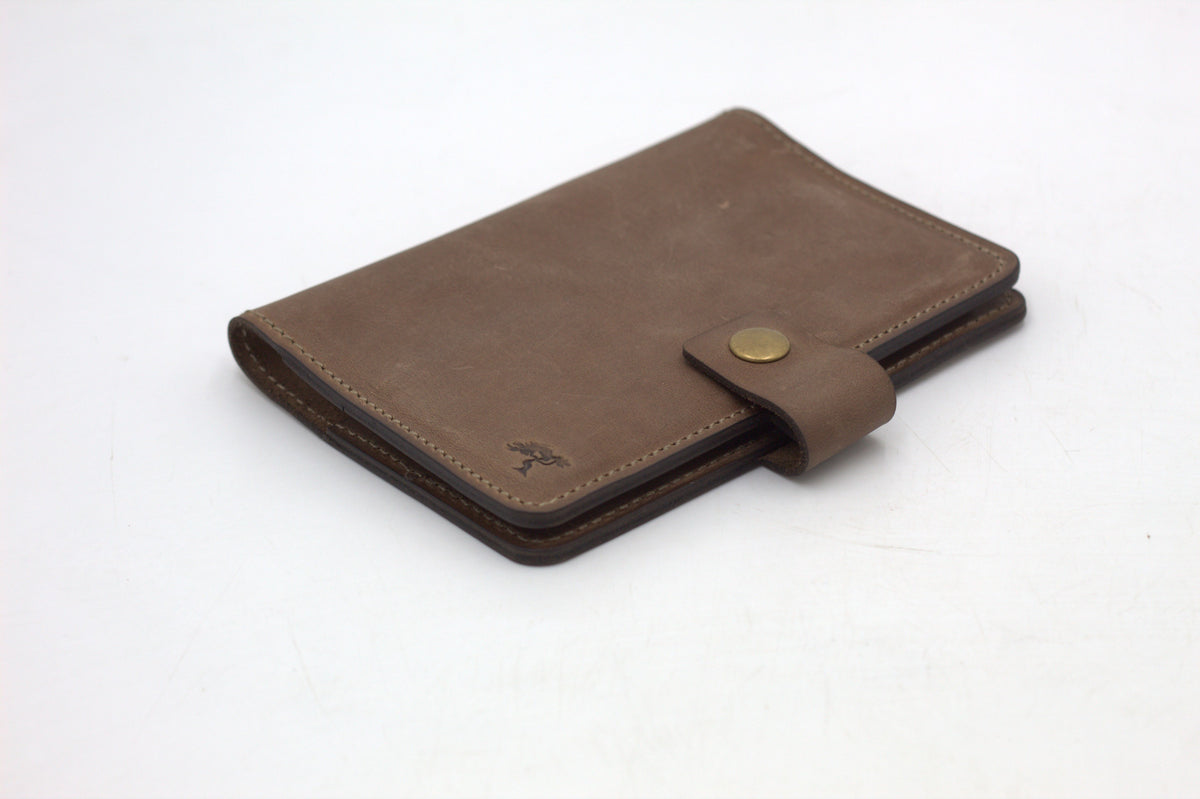 A black travel-wallet with a snap closure, displayed on a white background.
