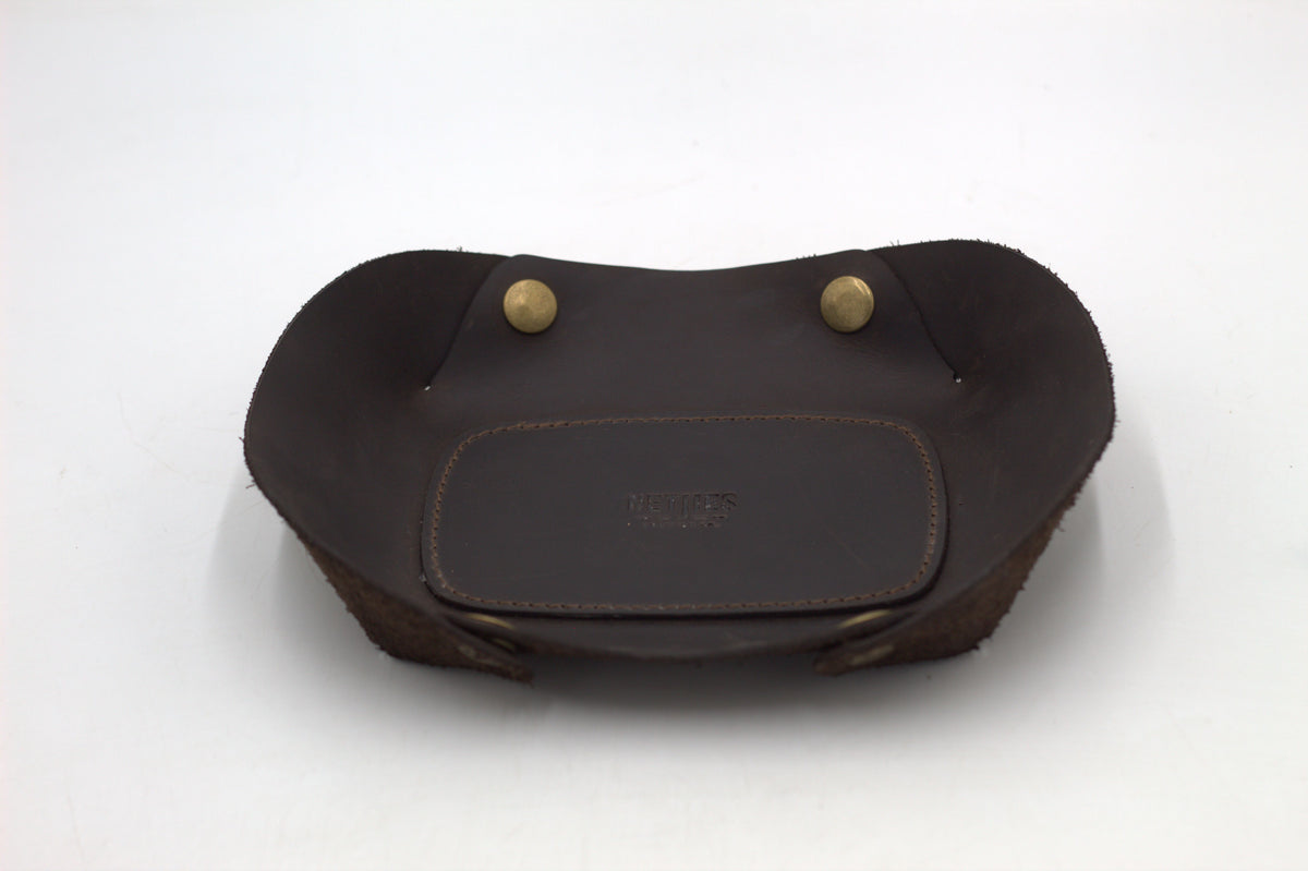 A black leather vallet tray with two metal studs, photographed on a white background.