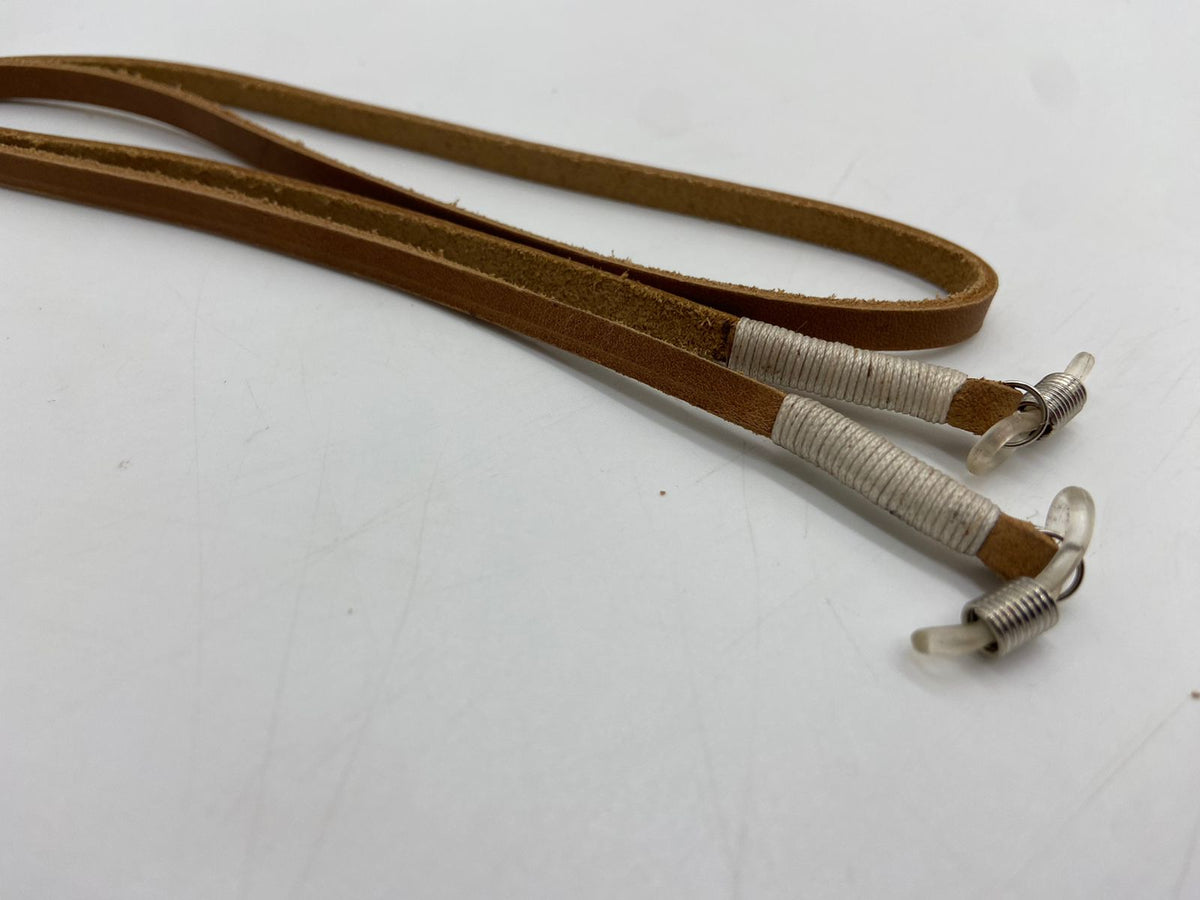 Two leather straps with metal ends on a white background