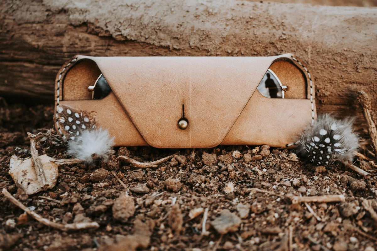 Brown leather wallet with decorative studs on a natural background