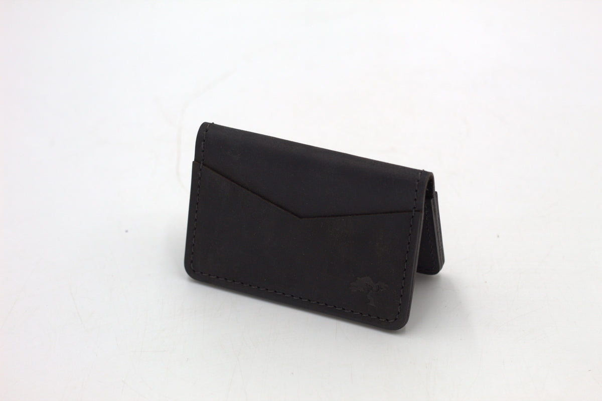 A black leather wallet with a front flap and metal accents, isolated on a white background.