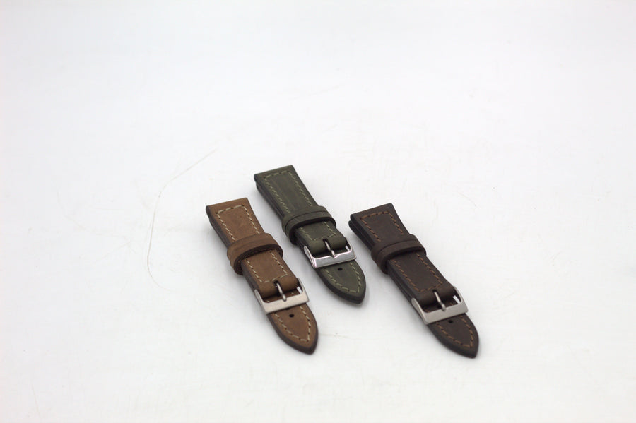 Three leather watch straps in brown, black, and green colors, displayed on a white background.